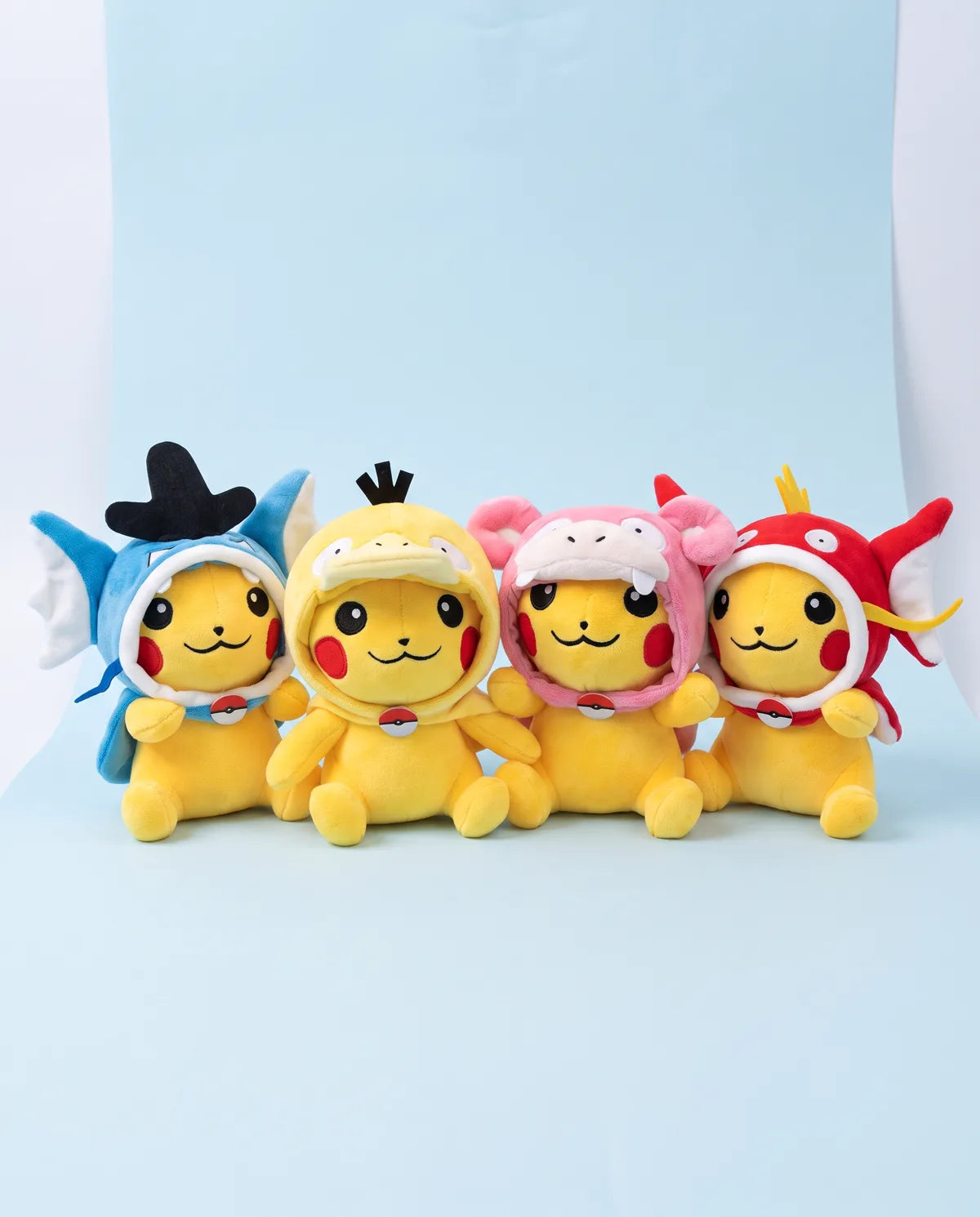 All four Little Swimmers plush side by side: blue fins, duck hood, pink hood and red fins