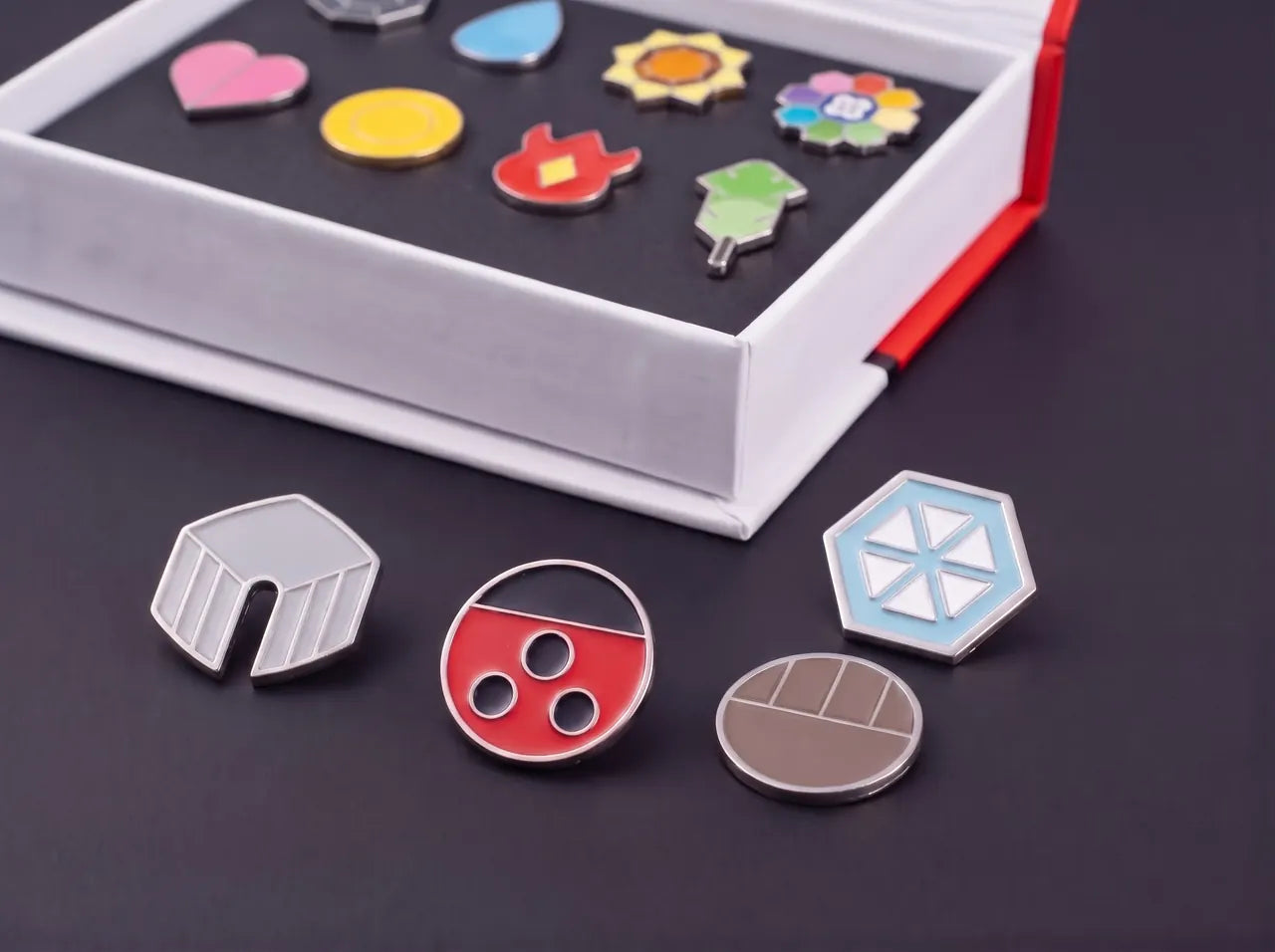 The Kanto gift box open with its eight badges, four Johto badges lying in front of it